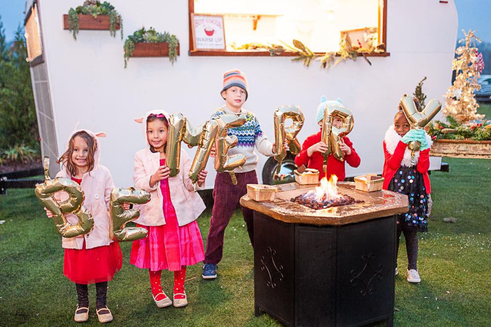 kids smiling with be merry sign at winter wonderland party